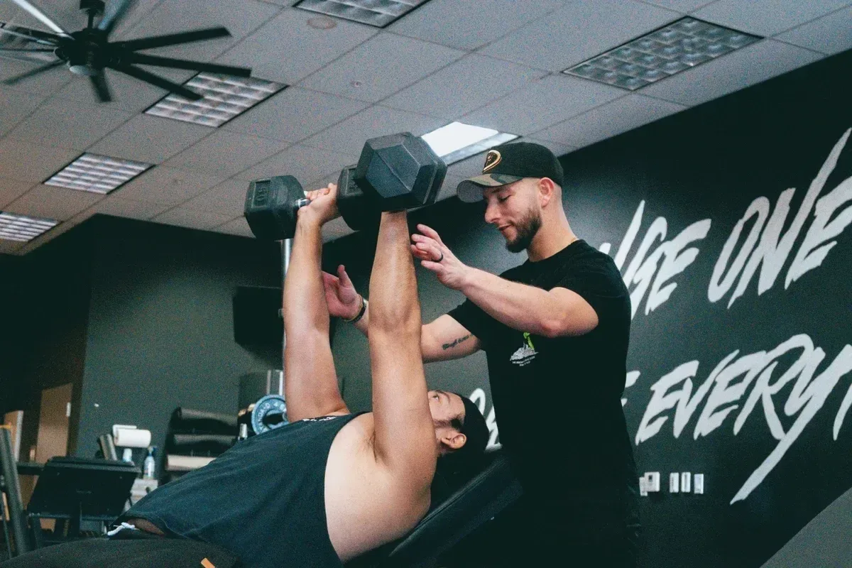 Personal Trainer helping a client during a strength training session
